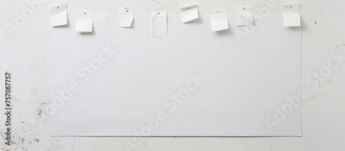 A grey rectangle white board with sticky notes in monochrome color scheme hangs on a white wall. The event details are written in font on paper