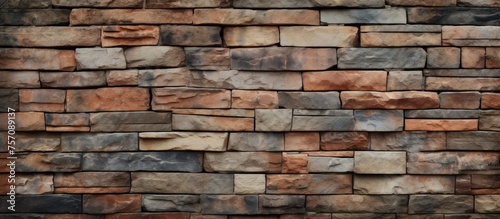 A closeup of a brown brick wall showcasing different types of bricks, forming a composite material. The bricks are rectangular in shape, creating a unique brickwork pattern on the stone wall