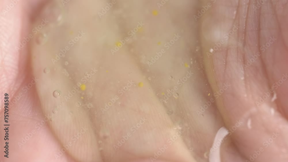 A woman pours shower gel into her palm, close-up. Skin care concept.