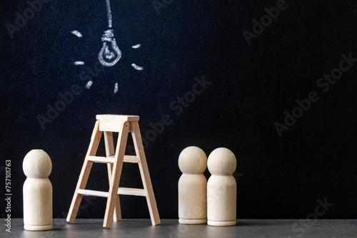 Glowing light bulb drawn with chalk on blackboard with wooden ladder and people figurines, concept of new ideas, innovations and solutions in business