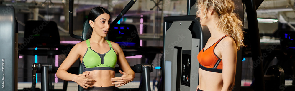 energetic female coach consulting her joyous client in gym near shoulder press machine, banner energetic female coach consulting her joyous client in gym near shoulder press machine, banner