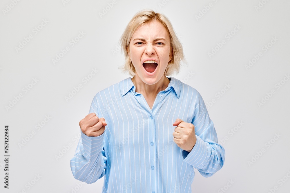 Angry woman yelling with clenched fists on white background expressing frustration or strong emotion Angry woman yelling with clenched fists on white background expressing frustration or strong emotion