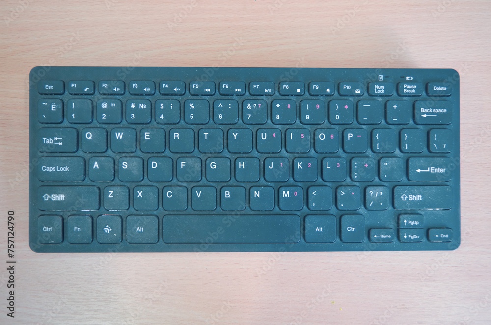 Wireless mini keyboard on a background of a wooden surface. Wireless mini keyboard on a background of a wooden surface.