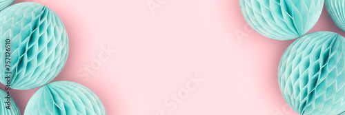 Banner with frame made of blue tissue paper balls on a pink background. Creative festive composition.