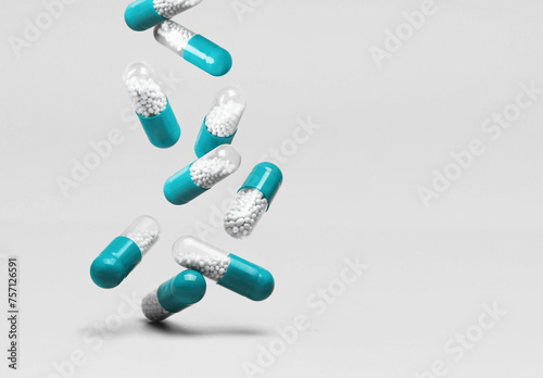 Falling blue and white capsules on a white background.