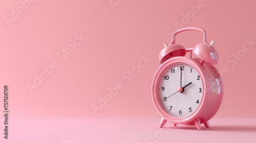 A pink alarm clock sits on a matching pink background