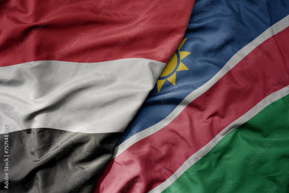 big waving national colorful flag of namibia and national flag of yemen .