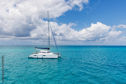 White sailing boat traveling in Maldives blue sea water on a bright sunny summer day in the middle of nowhere. Tropical sea and sailing boat. No sails up in calm sea waves. Freedom adventure tourism