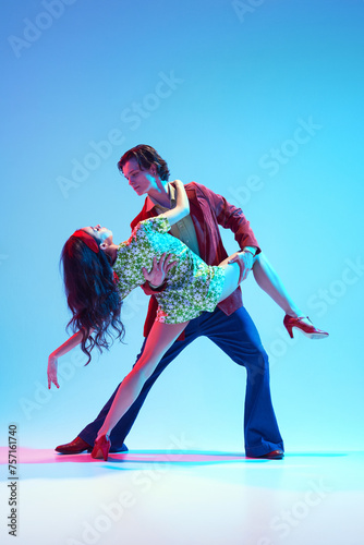 Event poster. 50s themed parties, musical events, capturing era's vibe. Young man and woman dancing against blue background in neon light. Concept of hobby, dance class, party, 50s, 60s culture, youth