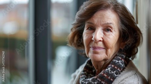 A mature woman stands by the window with a thoughtful gaze, reflecting life's experiences and wisdom