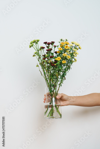 Woman hand hold Colorful flowers bouquet in mason jar on background. Happy day with fresh flower