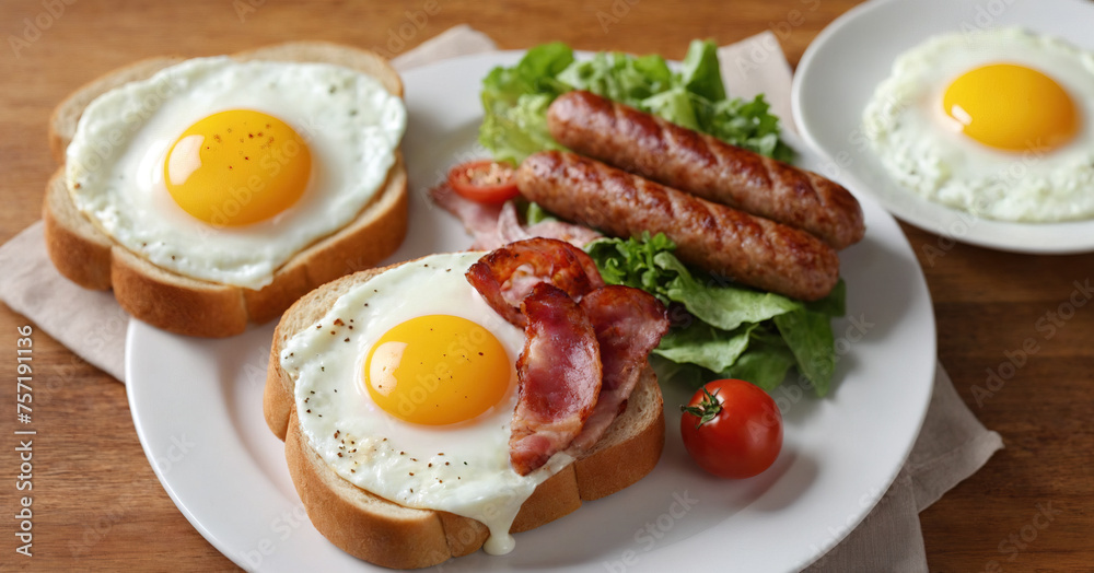 English breakfast with sausage, egg, bacon, and toast on white plate. English breakfast with sausage, egg, bacon, and toast on white plate.