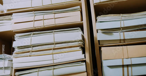 Stack of manila folders and bankers' boxes in office setting.