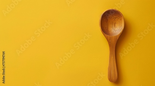 A wooden spoon rests on a vibrant yellow canvas