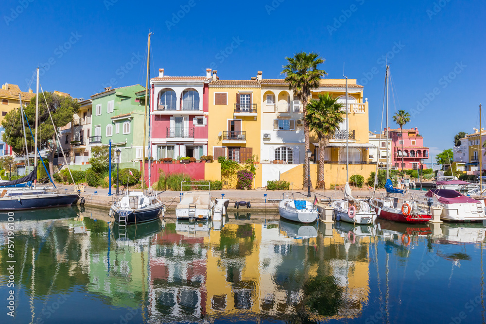 Colorful houses reflected in the water of Port Saplaya in Valencia, Spain