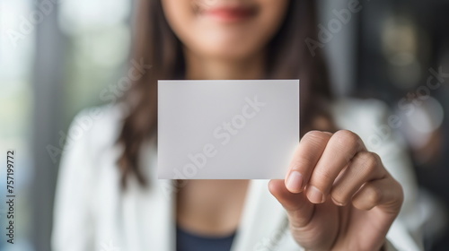 Business woman holds a clean business card in her hands, close-up