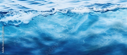 A closeup of a fluid azure wave in the ocean, shaped by the wind. The calm horizon creates a natural landscape of water and wind