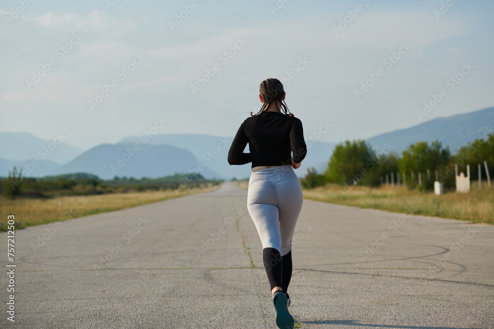 A determined woman athlete trains for success in the morning sun.