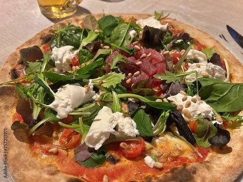 pizza with raw tuna, burrata, pine nuts, salad, tomatoes, modern fresh pizza