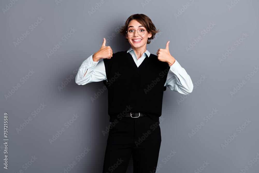 Photo of cheerful glad gorgeous girl wear black trendy clothes recommend quality product confirm project isolated on gray color background Photo of cheerful glad gorgeous girl wear black trendy clothes recommend quality product confirm project isolated on gray color background