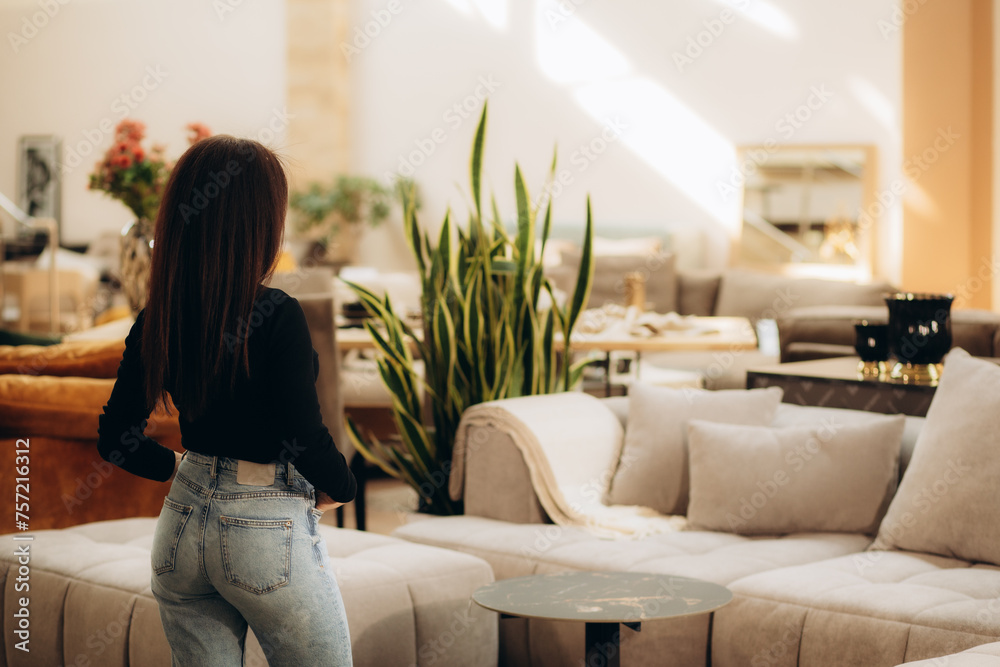 a woman examines a sofa in a furniture store a woman examines a sofa in a furniture store