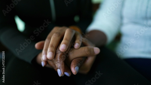 African American Granddaughter holding grandmother's hands and caring embrace showing love and support at family member in old age, teen girl kisses grandma's forehead © Marco