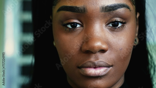 Foto Macro close-up portrait of a serious young black woman looking directly at camera with solemn expression