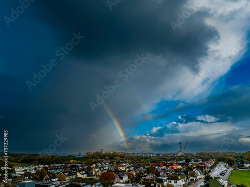 Dramatic sky over a suburban landscape with a rainbow