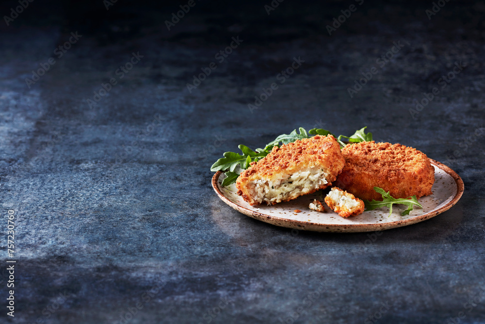 A delectable serving of crispy croquettes on a rustic plate garnished with fresh greens A delectable serving of crispy croquettes on a rustic plate garnished with fresh greens