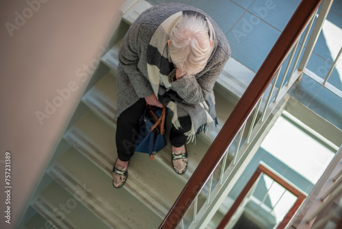 Elderly person paused on stairs, contemplating the next step. photo