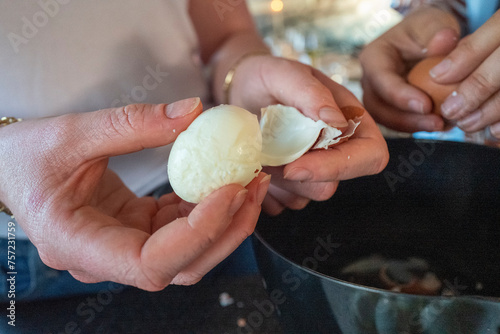 Hands peeling a hardboiled egg with precision photo