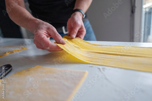 Hands preparing homemade pasta on kitchen counter