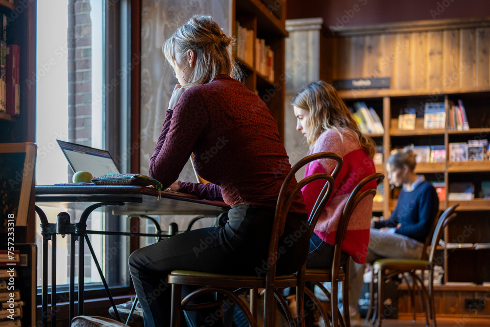 Focused individuals working in a cozy bookstore caf atmosphere Focused individuals working in a cozy bookstore caf atmosphere