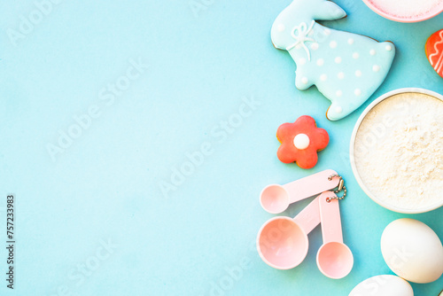 Easter baking, Flour, edds, sugar and gingerbread cookies. Top view on blue. photo