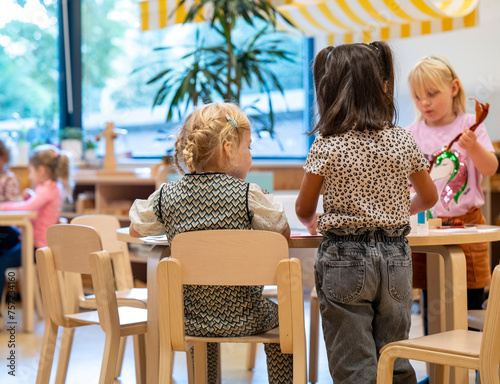 Little classmates engaged in a creative activity at preschool photo