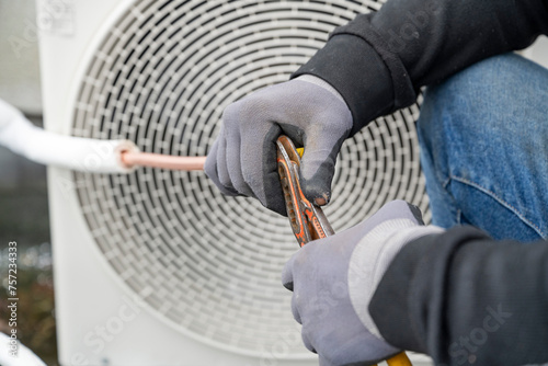 A technician servicing an outdoor air conditioning unit.
