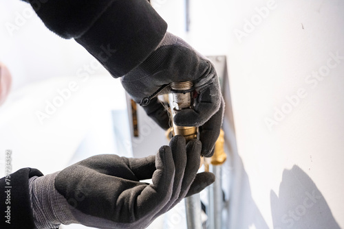 Hands carefully adjusting a light bulb into a fixture. photo