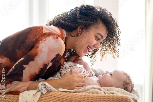 A joyful moment between mother and baby bathed in soft light. photo