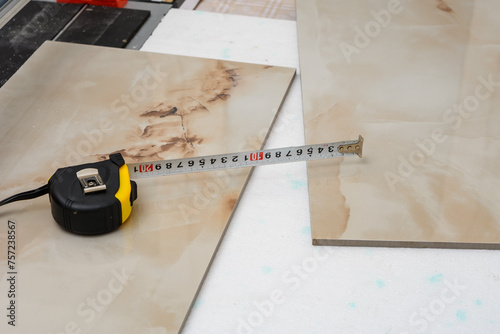 Mierzyć centymetrem płytki podłogowe do nowego mieszkania, remont domu © Paweł Kacperek