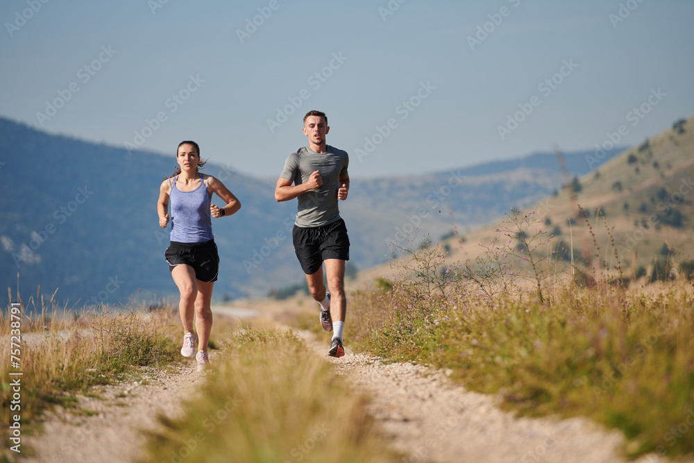 Energized by the beauty of nature, a couple powers through their morning run, their bodies and spirits invigorated.