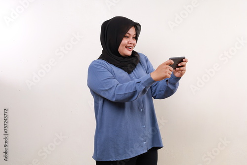 Happy asian adult woman standing while using cell phone © SetianingDyah