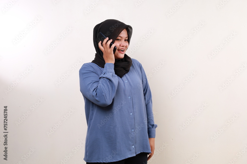 Happy excited asian adult woman standing while talking on the phone Happy excited asian adult woman standing while talking on the phone
