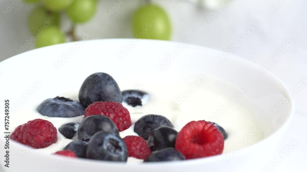 Bowl of white yogurt with with raspberry and blueberry, top view, rotation. Sour cream or fresh greek yogurt. Bowl of white yogurt with with raspberry and blueberry, top view, rotation. Sour cream or fresh greek yogurt.