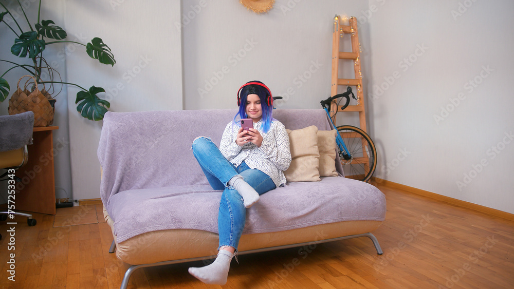 Obraz premium Young latin hispanic teenager girl using smartphone at home. Cozy home interior with indoor plants. Remote work, business, freelance, online shopping, e-learning, urban jungle concept
