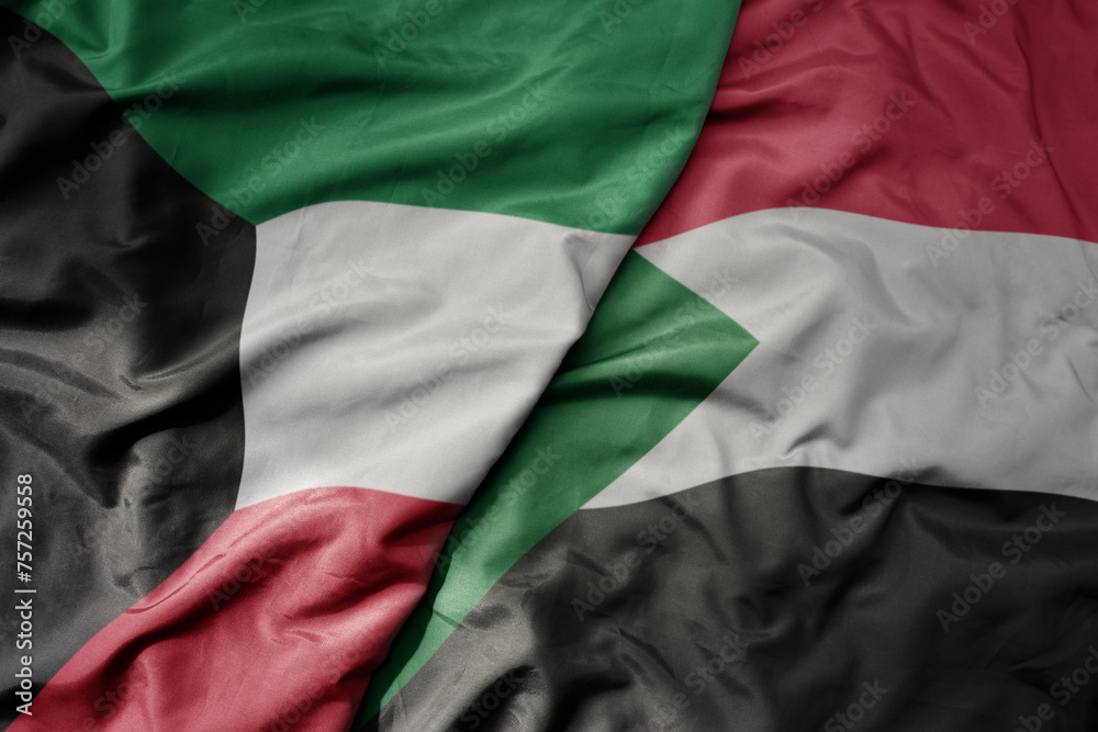 big waving national colorful flag of sudan and national flag of kuwait.