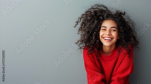 Radiant young woman laughing in vibrant red sweater