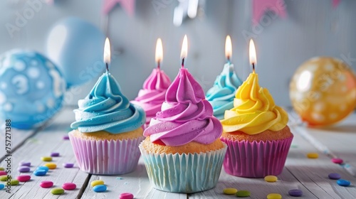 Colorful birthday cupcakes with lit candles