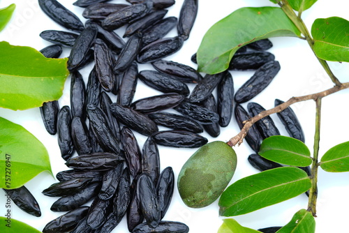 Dry tonka beans of the cumaru tree (Dipteryx odorata), also an unripe green fruit and leaves of the tree. It is a popular spice and medicine. Terra do Caju village, Amazonas, Brazil. photo