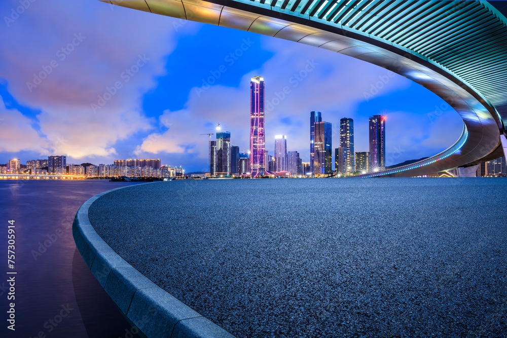 Fototapeta premium Empty asphalt road platform and bridge with modern city buildings scenery at night