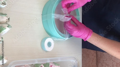 A woman measures a tape for packing homemade marshmallows. Nearby on the table tulips from Zephyra. Vertical video. photo